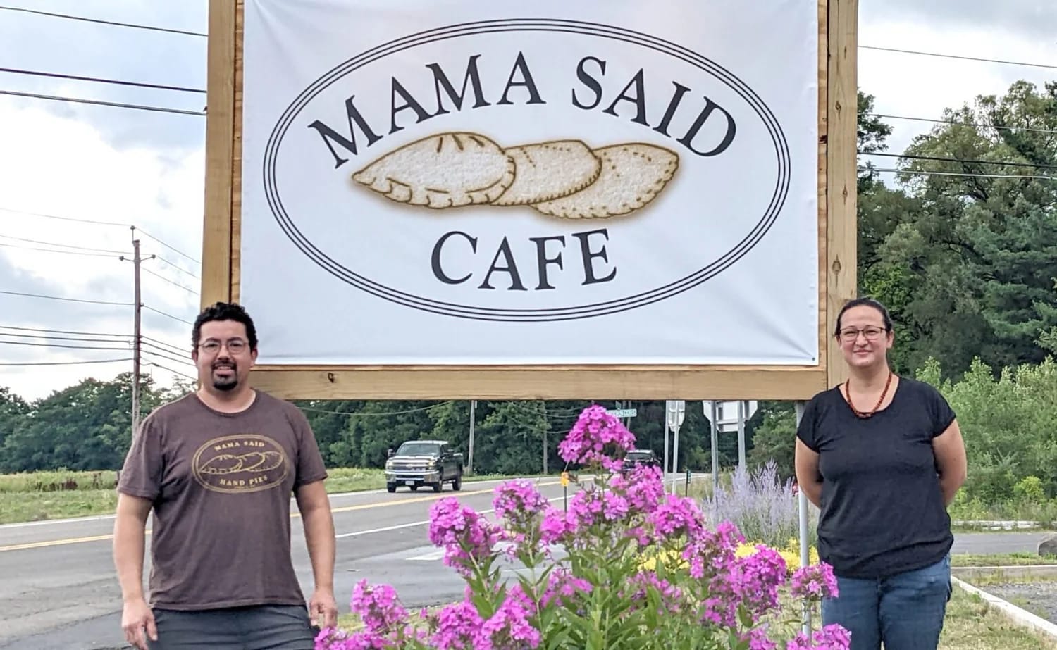 Owners Gabe and Hiroko standing next to the Mama Said Cafe sign on Trumansburg Road